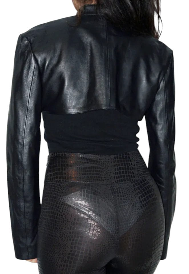 Woman wearing cropped black leather shrug jacket with long sleeves and open front, paired with black textured high-waist pants – Luxequir Vogue Midnight Shard