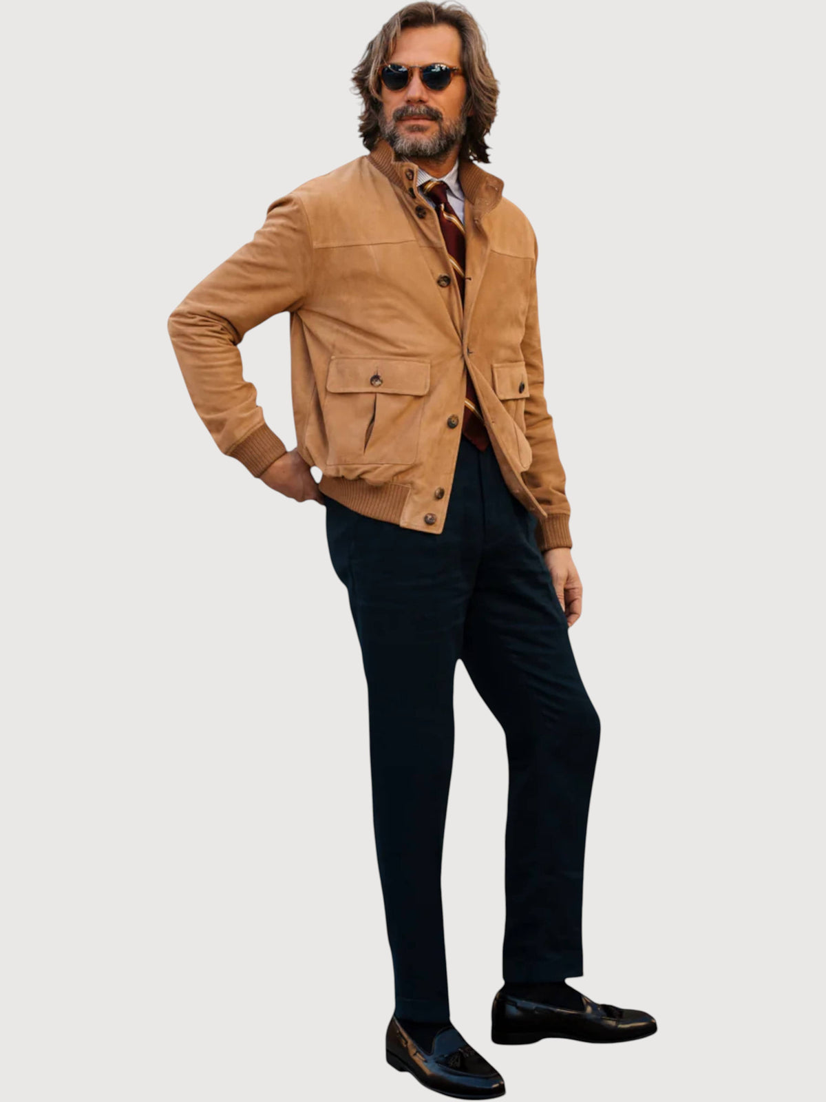 Luxequir Vogue caramel shearling bomber jacket worn by a man with sunglasses, dark trousers, and loafers.