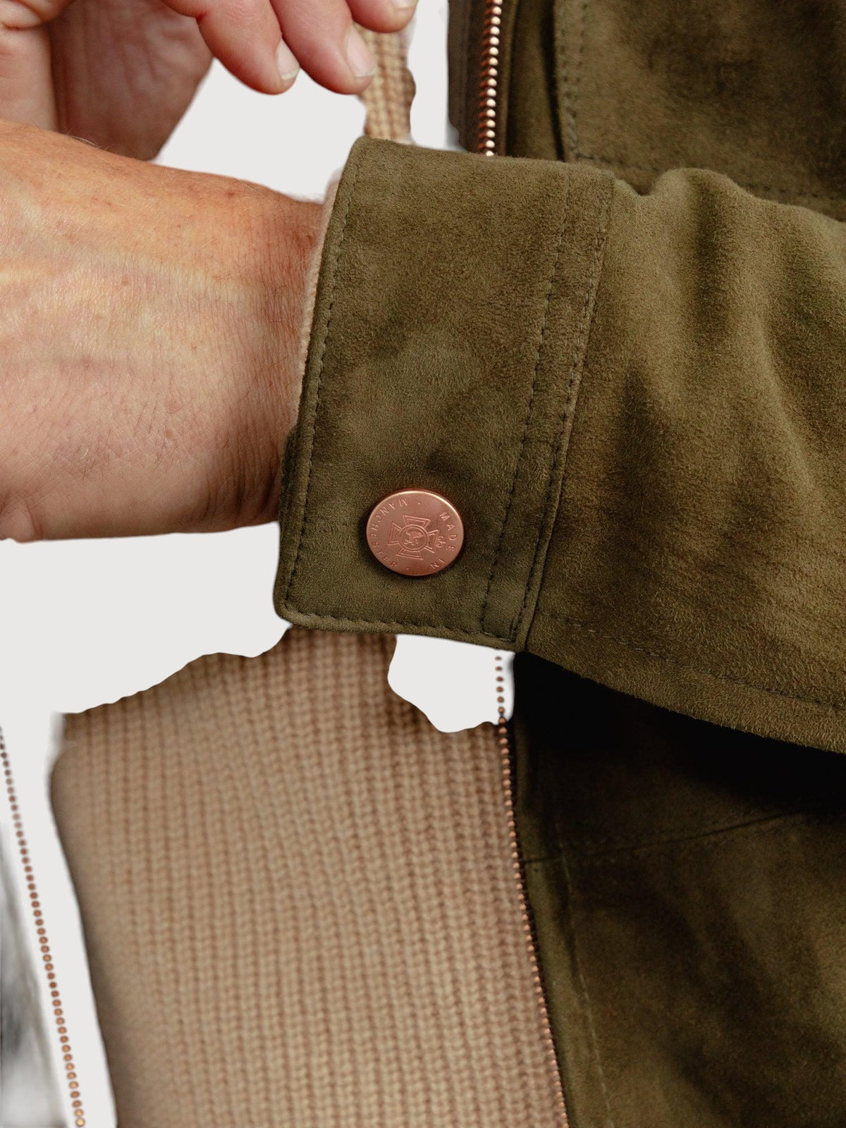 Luxequir Vogue moss green suede overshirt featuring a detailed metallic button on the cuff and textured panel design.