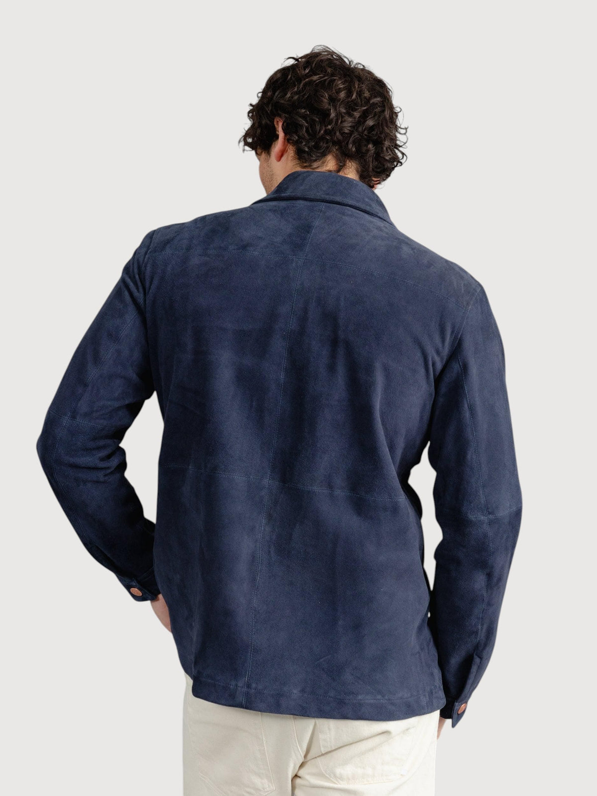 Back view of a man wearing a Luxequir Vogue navy blue suede panelled overshirt with a structured fit.