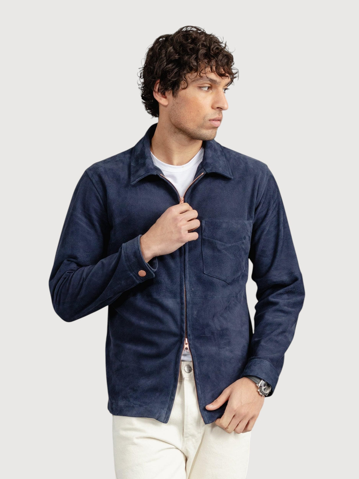 A man wearing a Luxequir Vogue navy blue suede overshirt with a front zip closure and chest pocket over a white tee.